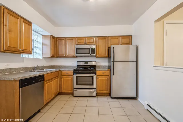 a kitchen with cabinets appliances and a window