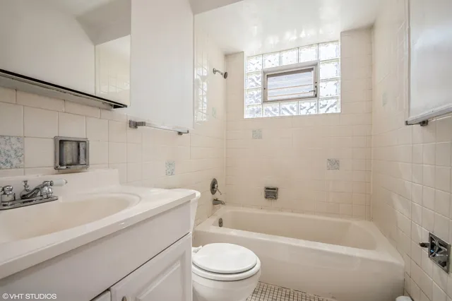 a bathroom with a granite countertop toilet a sink and a bathtub