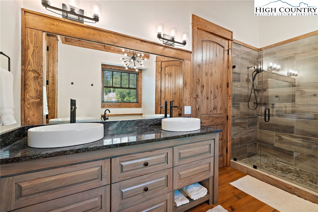 559 Marigold Road Boone, NC 28607 - Photo 18 of 46 a bathroom with a granite countertop sink a mirror and shower
