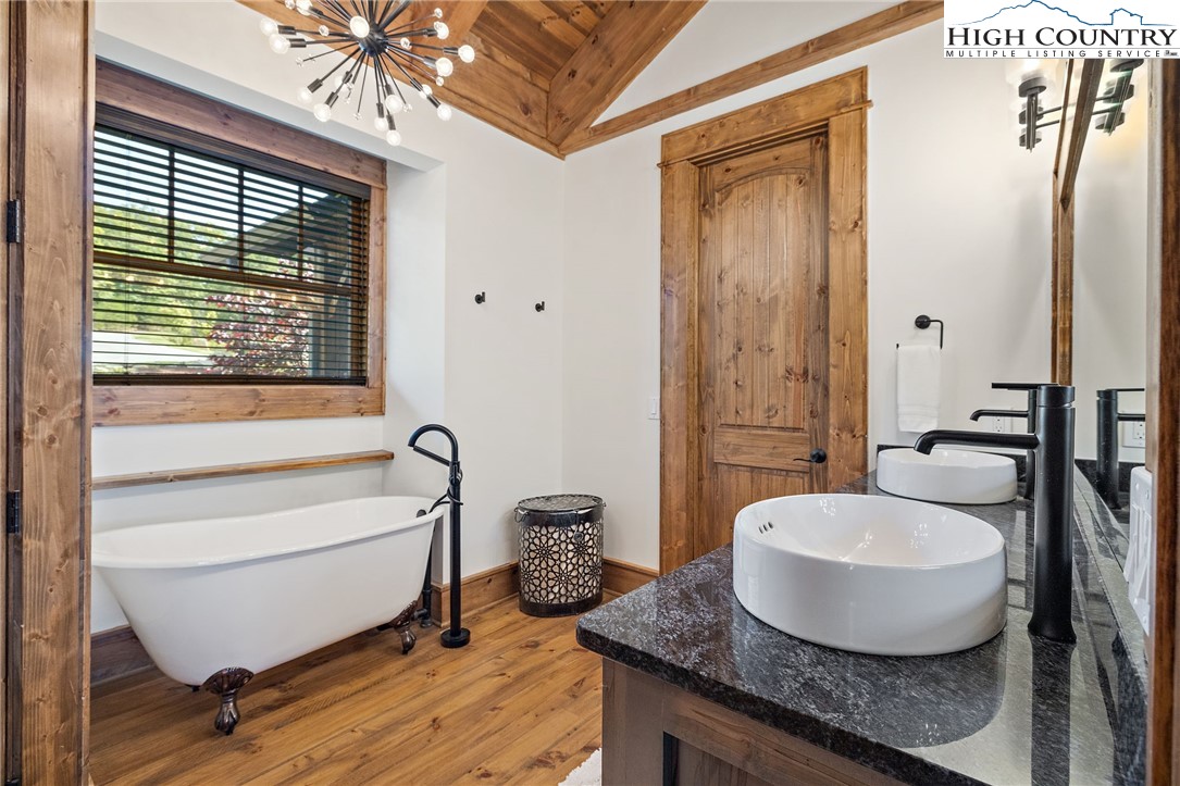 559 Marigold Road Boone, NC 28607 - Photo 19 of 46 a bathroom with a granite countertop tub a sink and a mirror