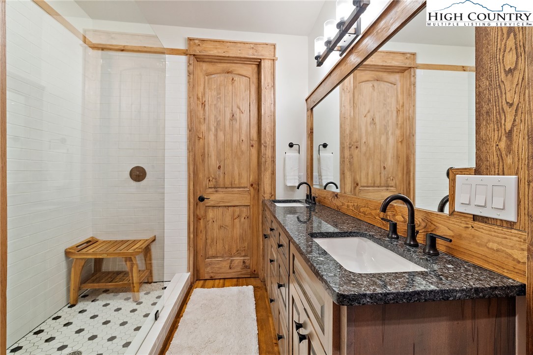 559 Marigold Road Boone, NC 28607 - Photo 30 of 46 a bathroom with a granite countertop sink a mirror a vanity and a shower