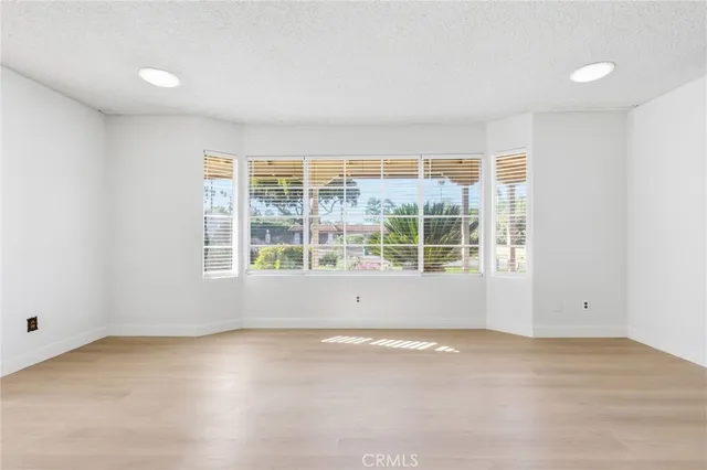 an empty room with a window and a ceiling fan