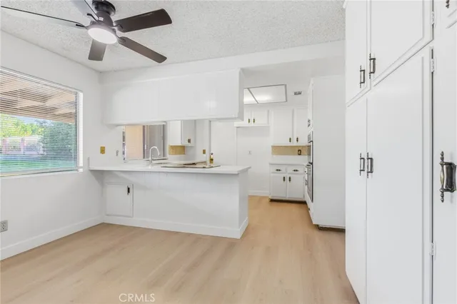 a kitchen with white cabinets and stainless steel appliances