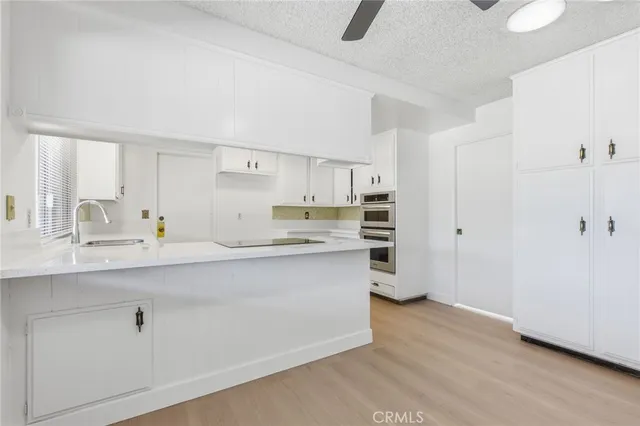 a kitchen with white cabinets and a window