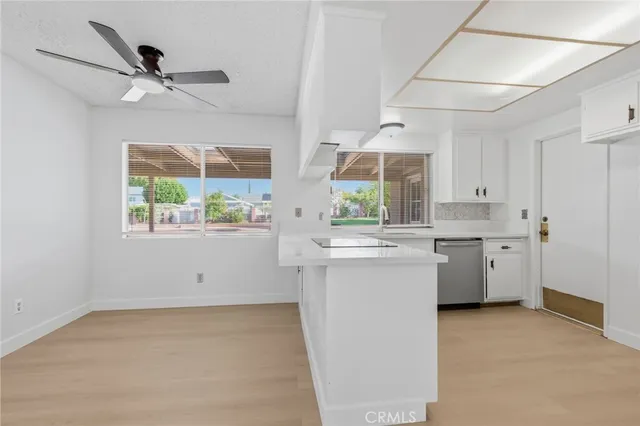 a kitchen with stainless steel appliances white cabinets and a stove top oven