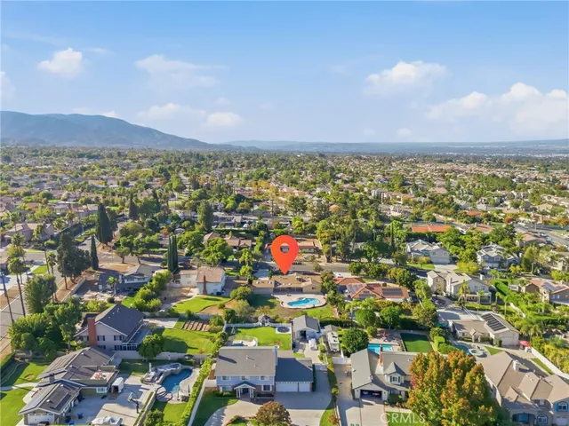 an aerial view of residential houses with outdoor space and parking