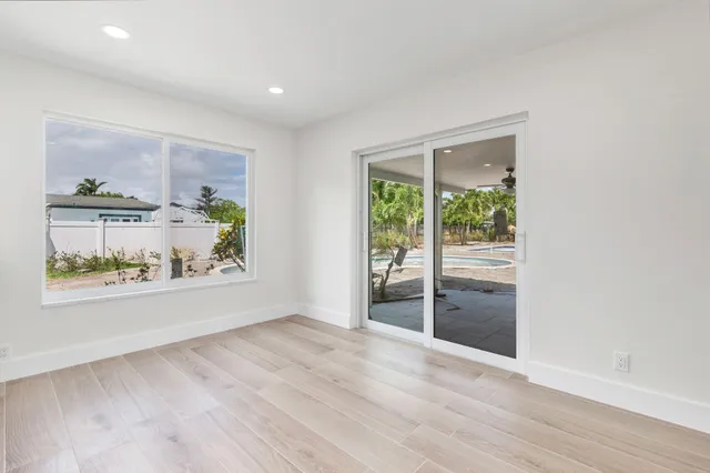 an empty room with wooden floor and window