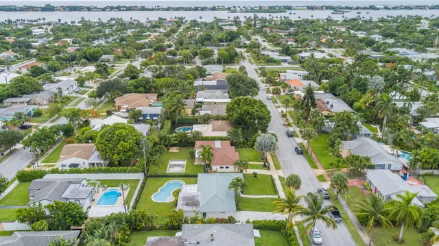 an aerial view of residential houses with outdoor space and trees