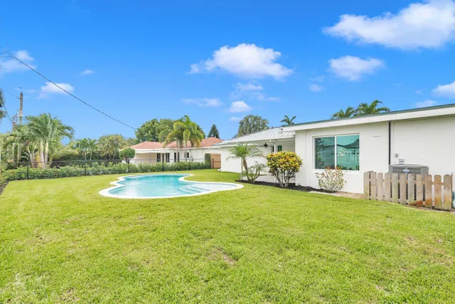 a view of a house with swimming pool and a yard
