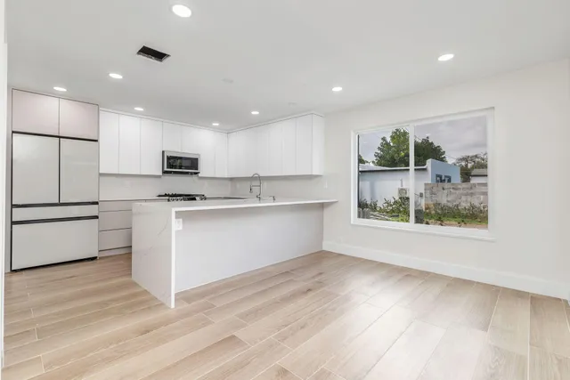 a kitchen with stainless steel appliances a refrigerator sink and microwave