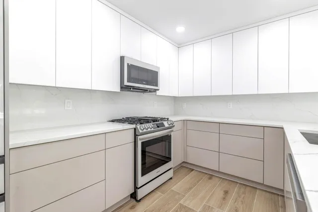 a kitchen with granite countertop white cabinets and appliances