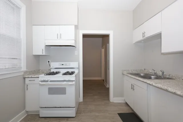 a kitchen with white cabinets and white appliances