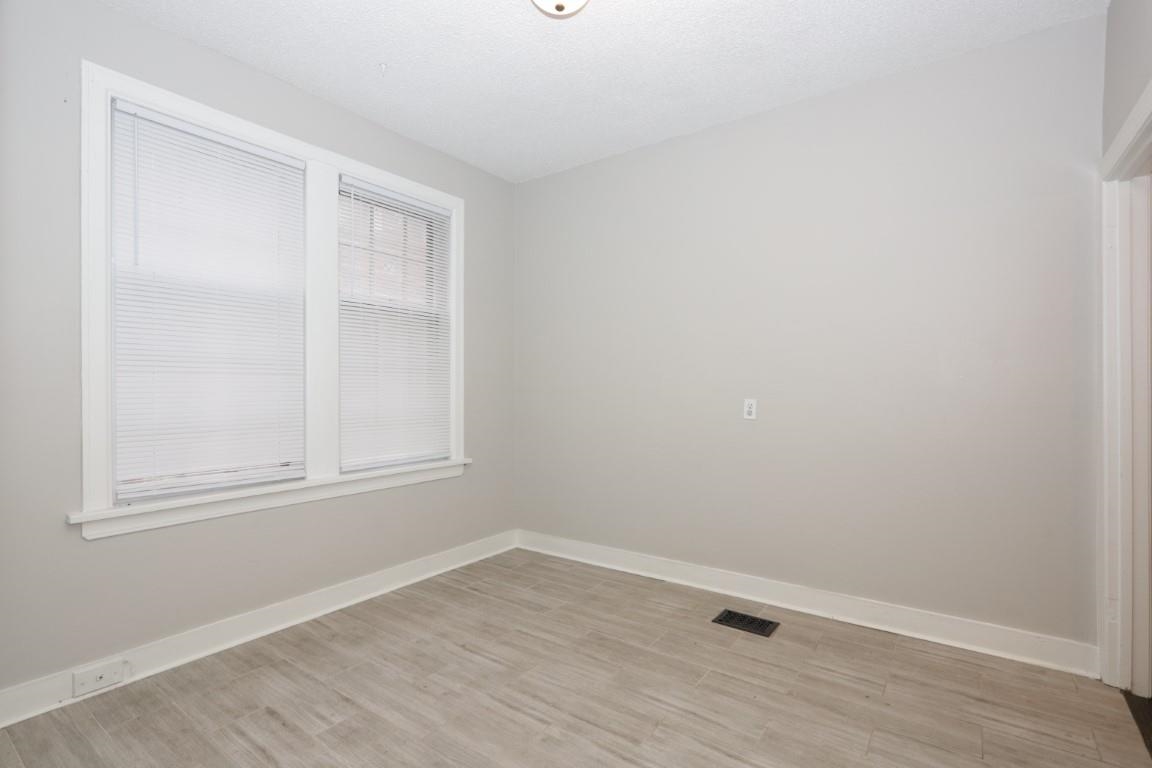 2367 Forrest Avenue, Unit 1 Memphis, TN 38112 - Photo 6 of 9 a view of an empty room with wooden floor and a window
