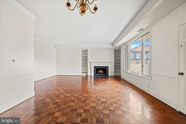 a view of an empty room with a fireplace and a window