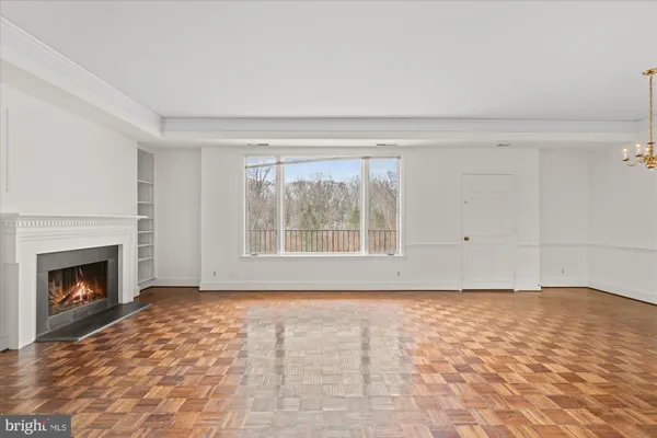 a view of empty room with wooden floor and fireplace