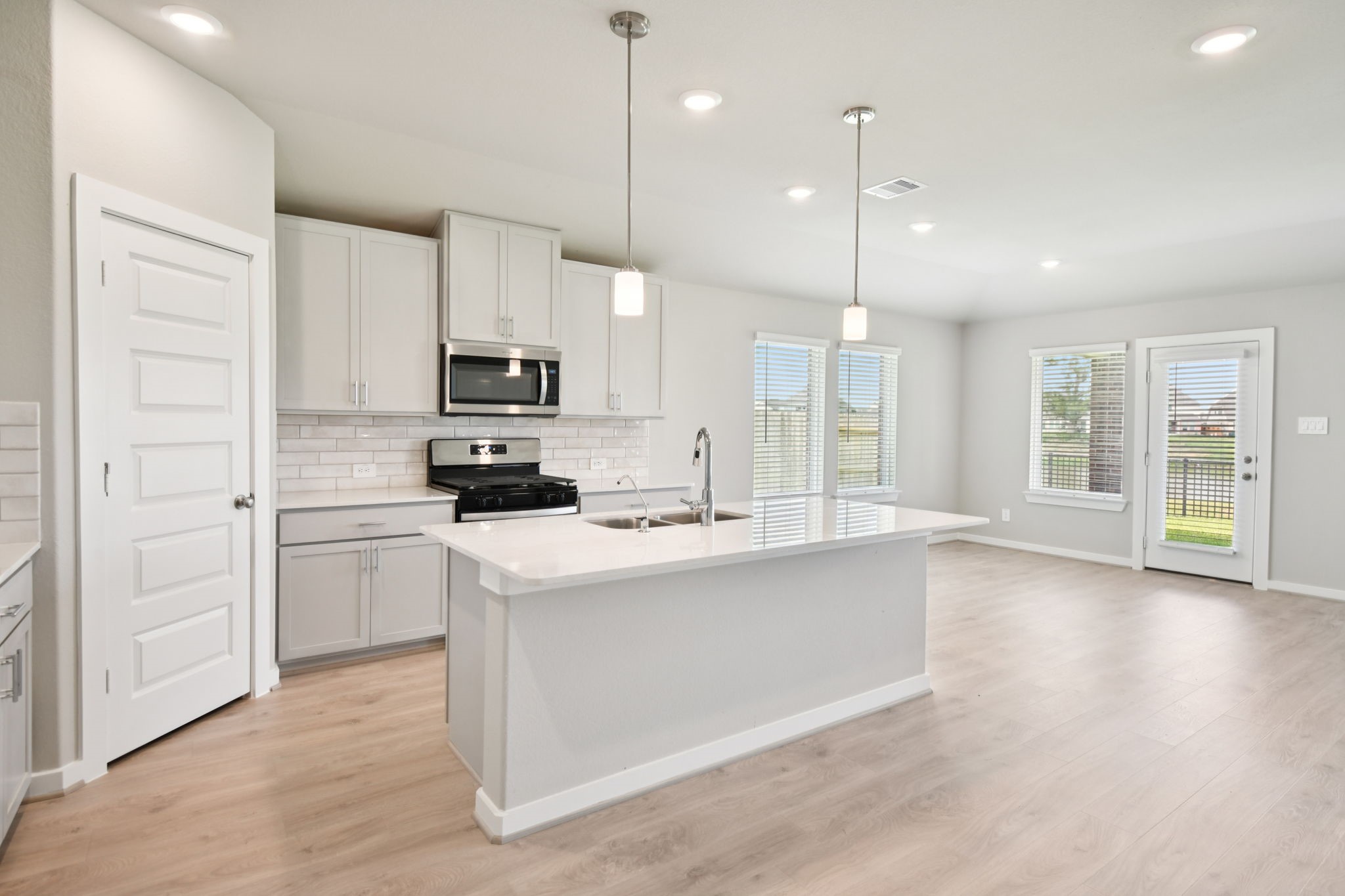 1672 Hopson Ranch Drive Conroe, TX 77301 - Photo 2 of 44 a kitchen with kitchen island a stove a sink and a refrigerator with wooden floor