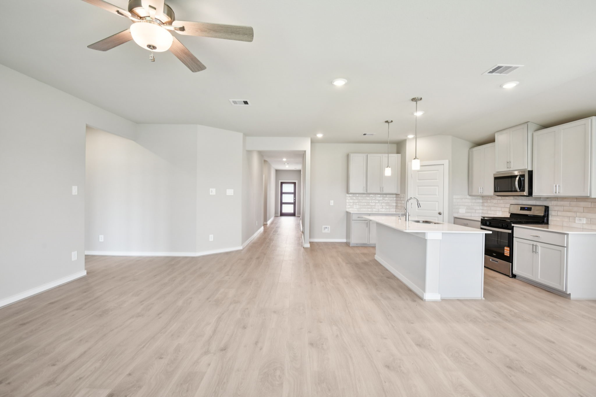1672 Hopson Ranch Drive Conroe, TX 77301 - Photo 10 of 44 a view of kitchen with refrigerator a microwave and white cabinets