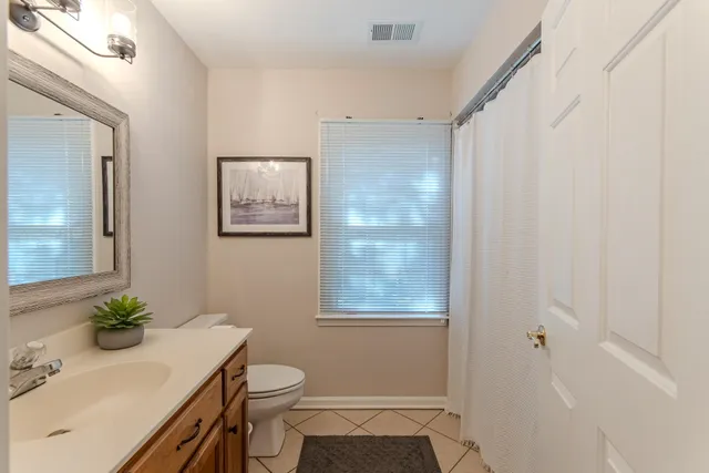 a bathroom with a sink a toilet and mirror