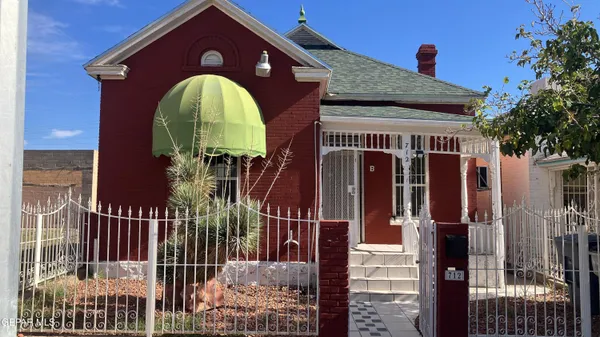 a view of a brick house with a iron gate
