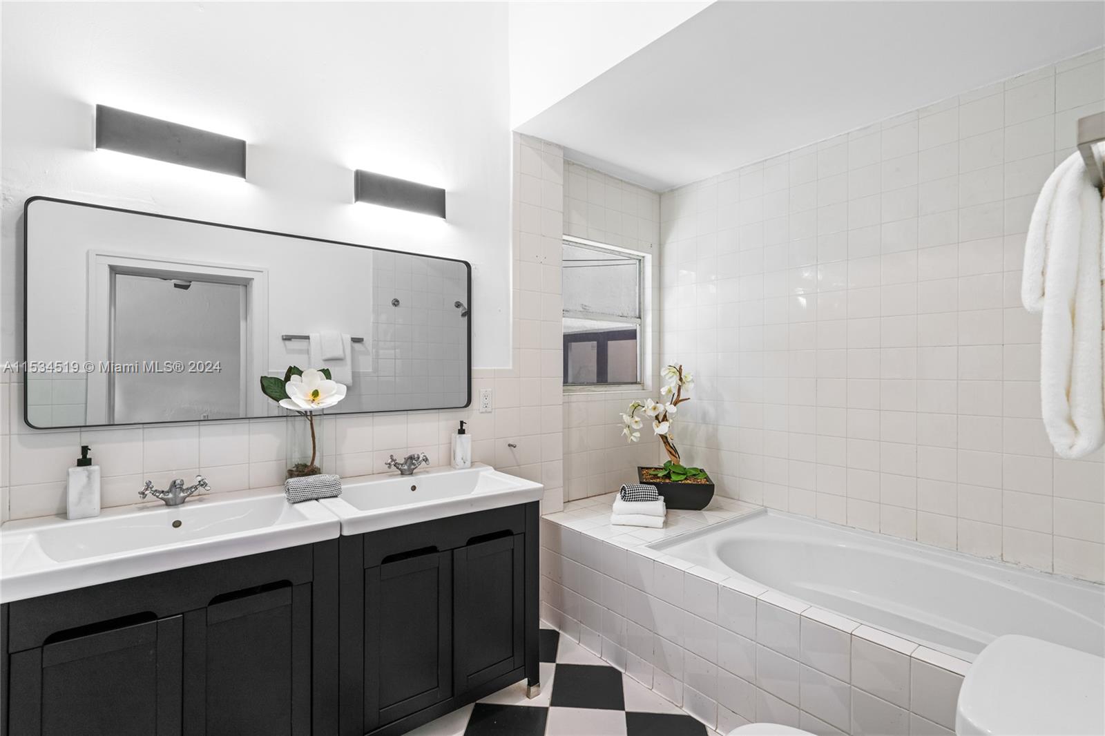 3871 South Le Jeune Road Miami, FL 33146 - Photo 25 of 49 a bathroom with a bathtub a double vanity sink and mirror
