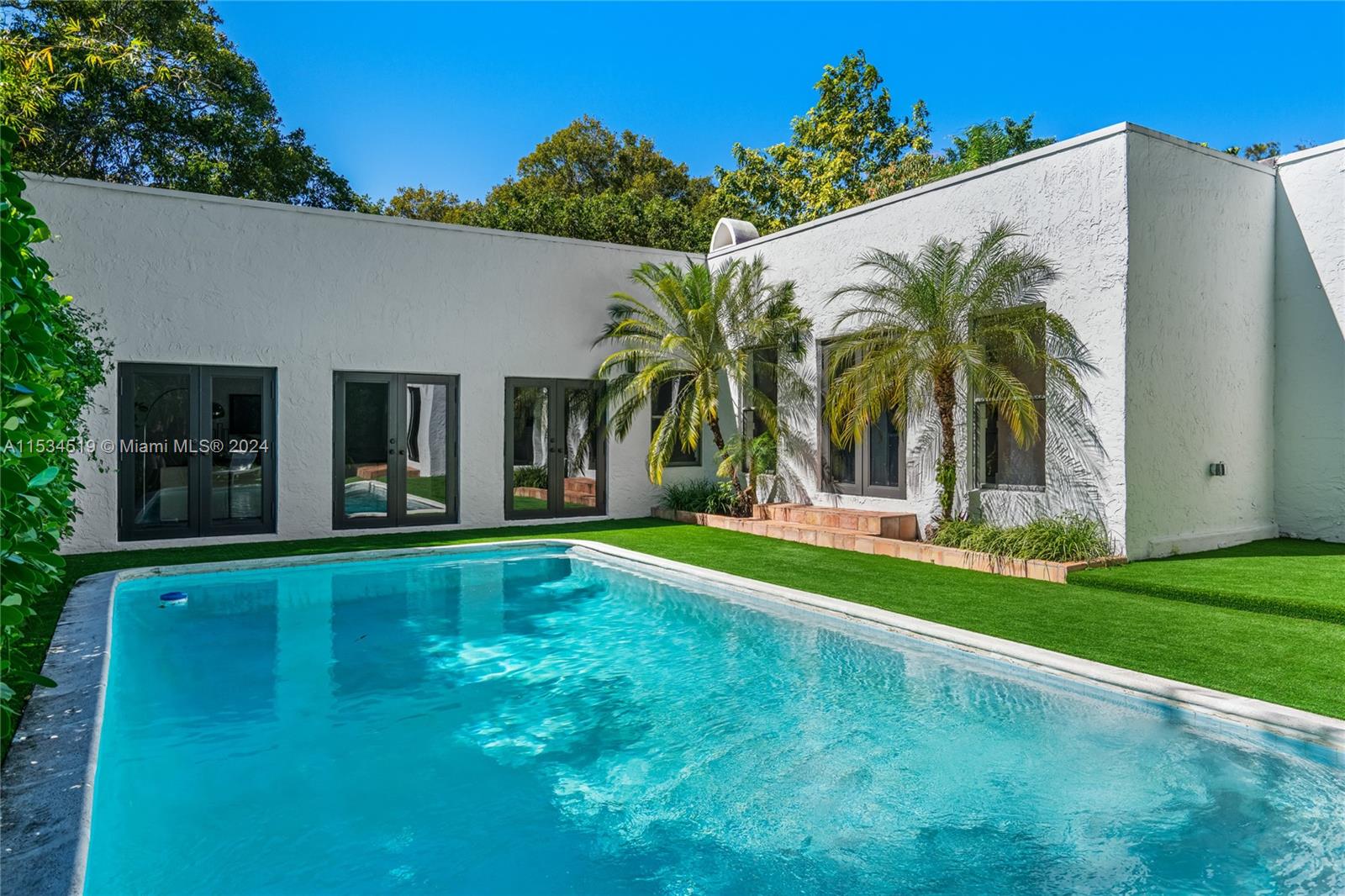 3871 South Le Jeune Road Miami, FL 33146 - Photo 39 of 49 a view of a white house with a big yard and potted plants