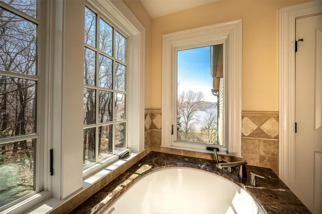 a view of a bathroom with tub and window