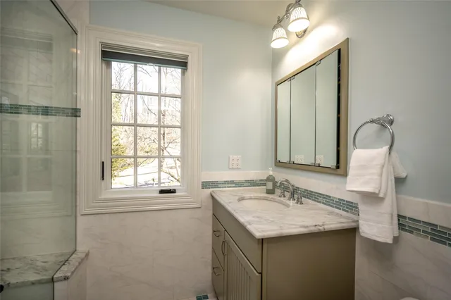 a bathroom with a granite countertop sink a mirror and a window