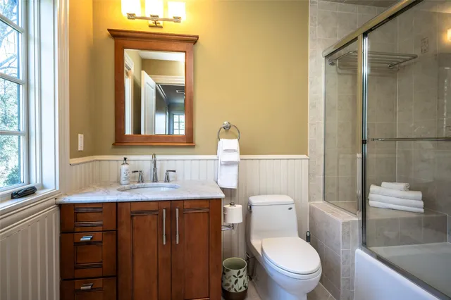 a bathroom with a granite countertop toilet sink and mirror