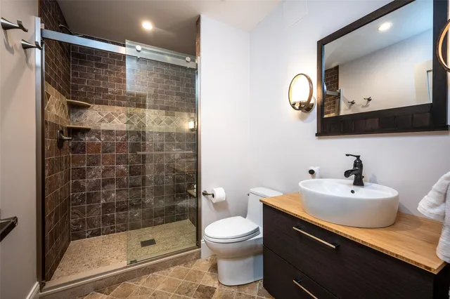 a bathroom with a sink toilet a mirror and shower