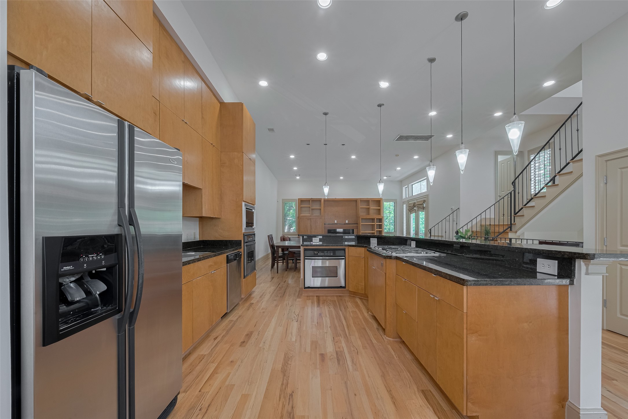 2034 Colquitt Street, Unit A Houston, TX 77098 - Photo 11 of 30 a kitchen with stainless steel appliances a refrigerator a stove top oven and wooden floor