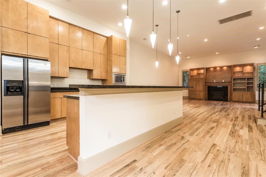 2034 Colquitt Street, Unit A Houston, TX 77098 - Photo 12 of 30 a kitchen with stainless steel appliances granite countertop a refrigerator a oven and a sink with wooden floor