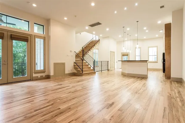 a view of a living room and a kitchen with wooden floors