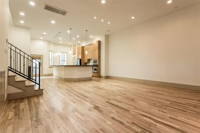 a view of a kitchen with kitchen island a sink wooden floor and a counter top space