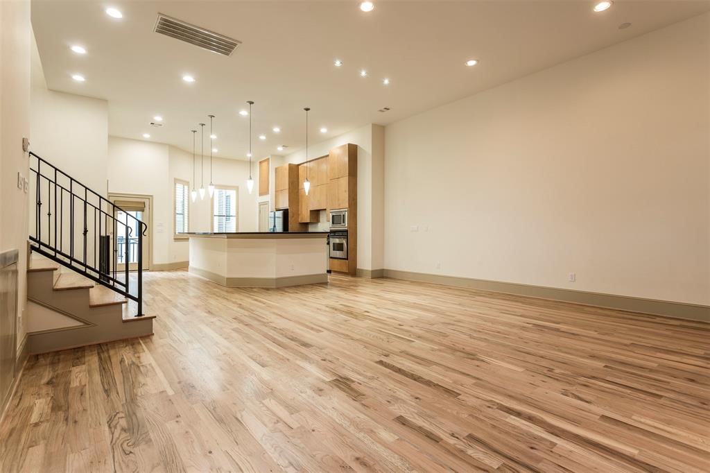 2034 Colquitt Street, Unit A Houston, TX 77098 - Photo 18 of 30 a view of a kitchen with kitchen island a sink wooden floor and a counter top space