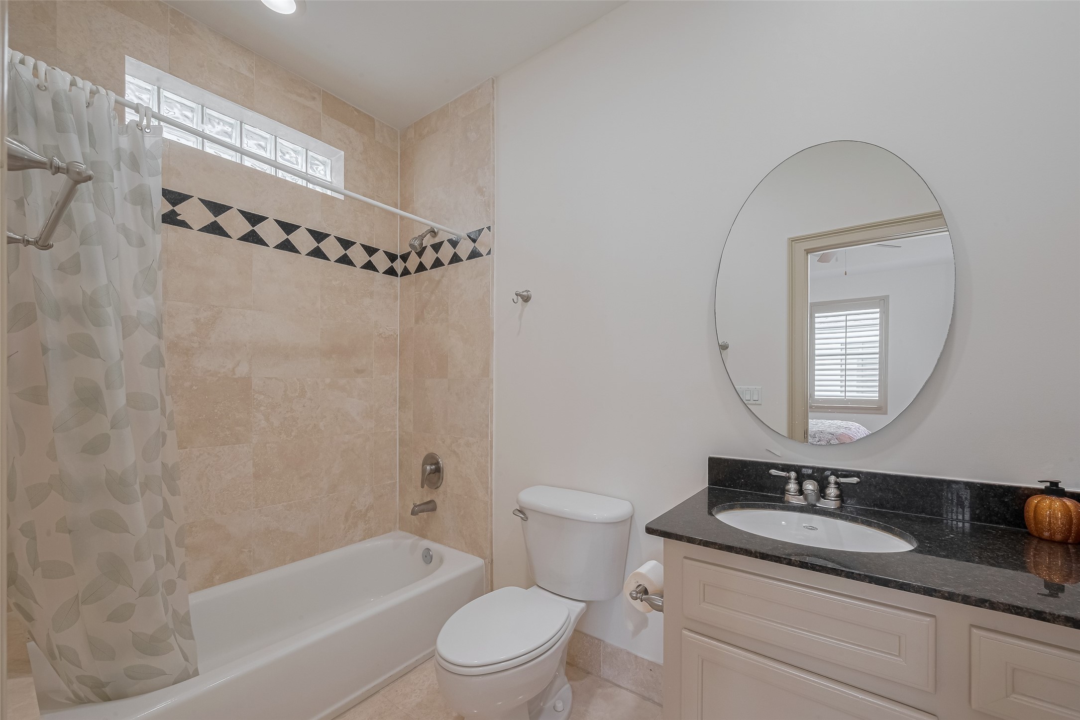 2034 Colquitt Street, Unit A Houston, TX 77098 - Photo 24 of 30 a bathroom with a granite countertop sink a toilet a mirror a vanity a bathtub and shower