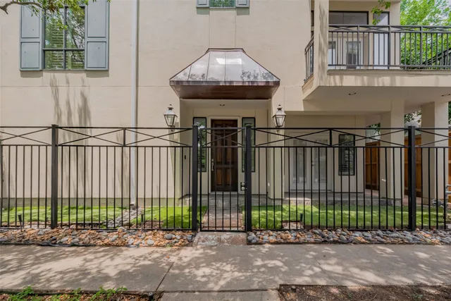 a view of a brick house with a small yard and plants
