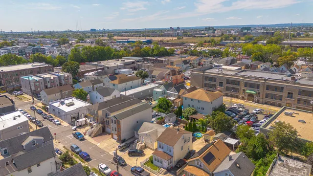 an aerial view of a city with lots of residential buildings ocean and mountain view in back