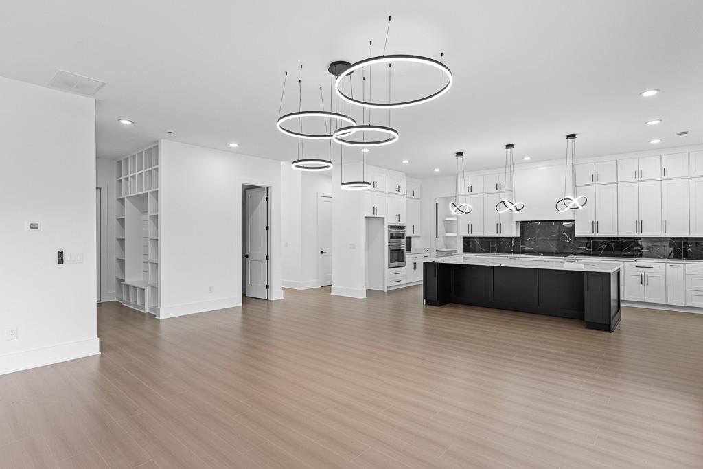 2404 Highway 124 Jefferson, GA 30549 - Photo 17 of 51 a large white kitchen with a refrigerator a microwave oven a sink and dishwasher with wooden floor