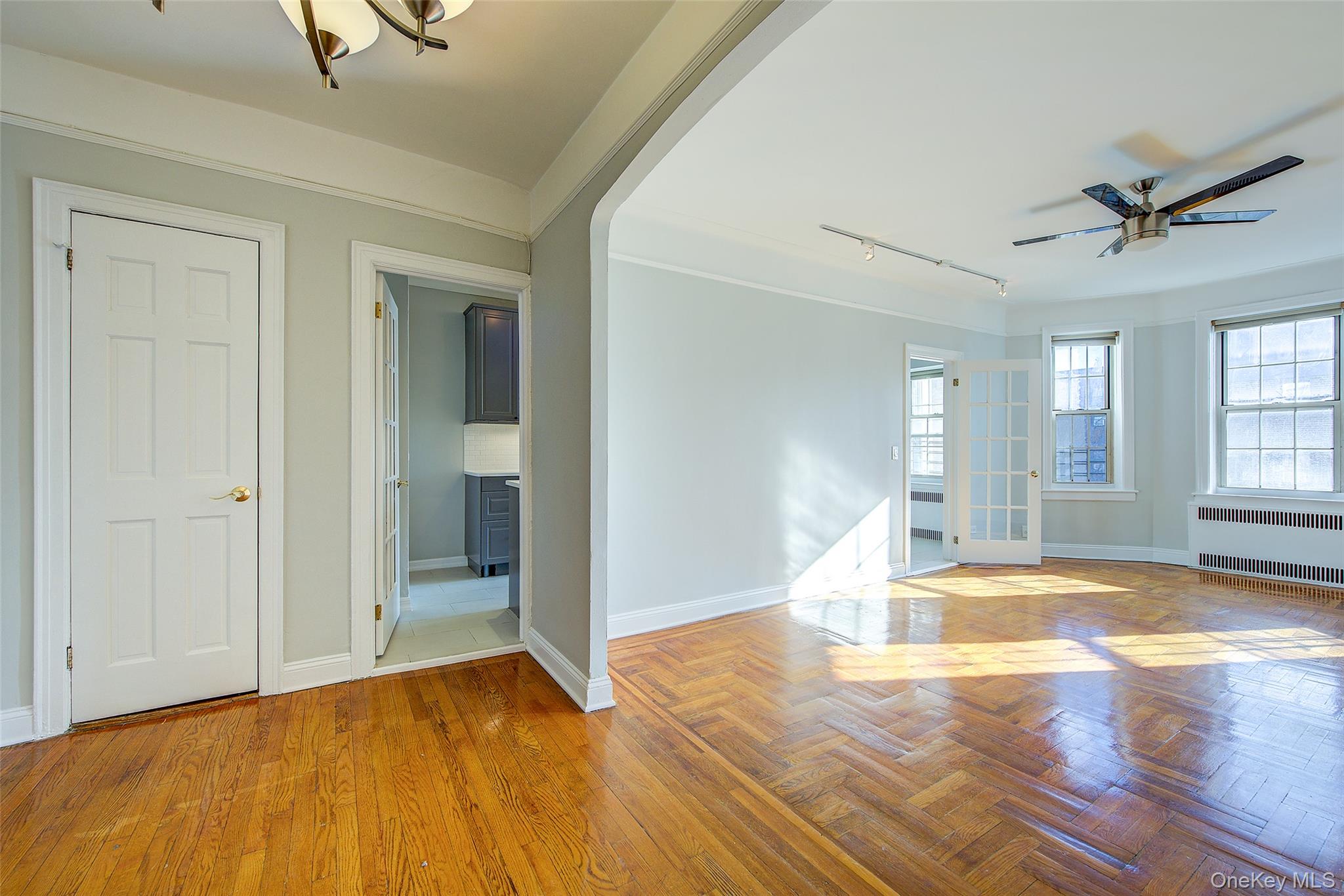 79-15 35th Avenue, Unit 5A Queens, NY 11372 - Photo 3 of 14 Foyer featuring track lighting, ceiling fan, radiator heating unit, and healthy amount of natural light