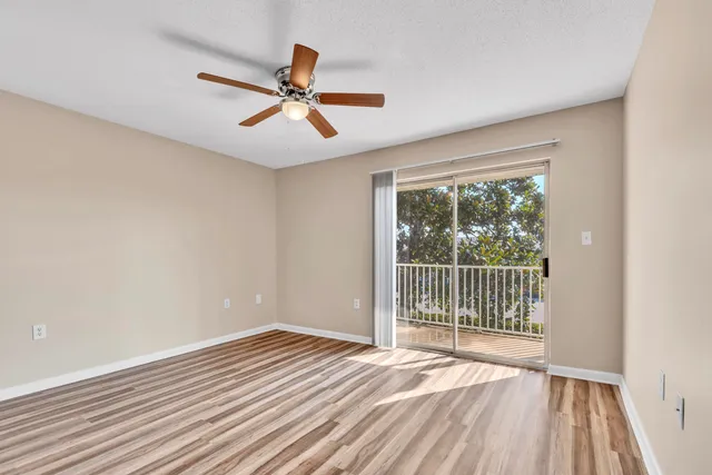 a view of a livingroom with wooden floor and a ceiling fan