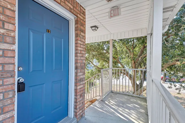 a view of a porch with wooden floor and front door