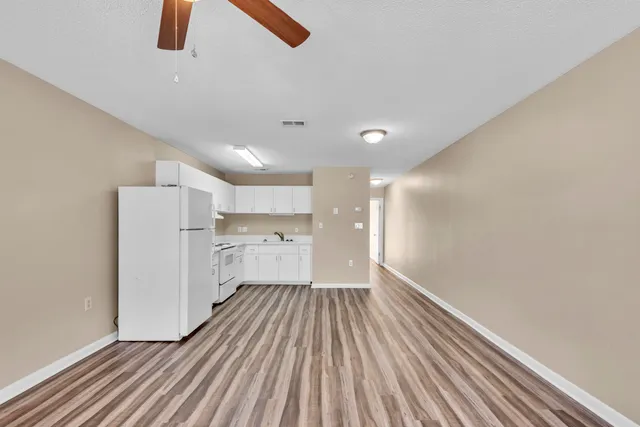 a view of a room with wooden floor and electronic appliances