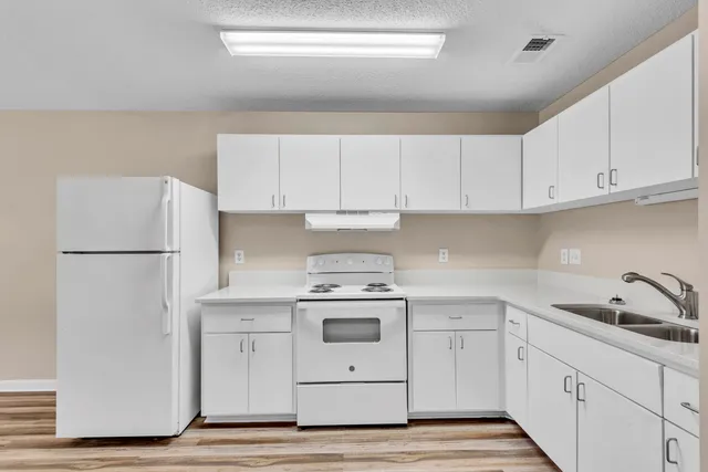 a kitchen with white cabinets and white appliances