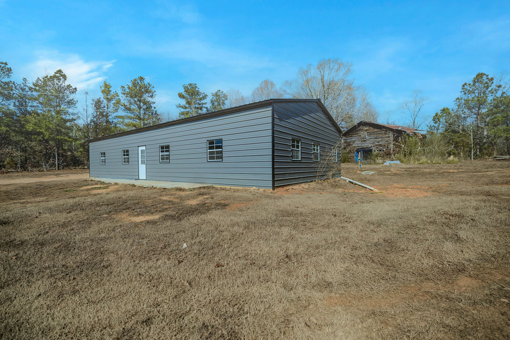 900 Asaville School Road Anderson, SC 29621 - Photo 12 of 29 This metal-sided structure offers a versatile space on an expansive rural lot, blending function with natural surroundings.