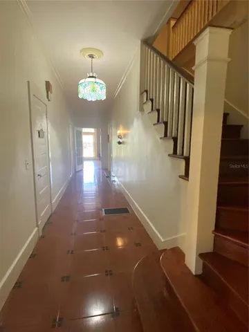 a view of a hallway with entryway wooden floor and front door