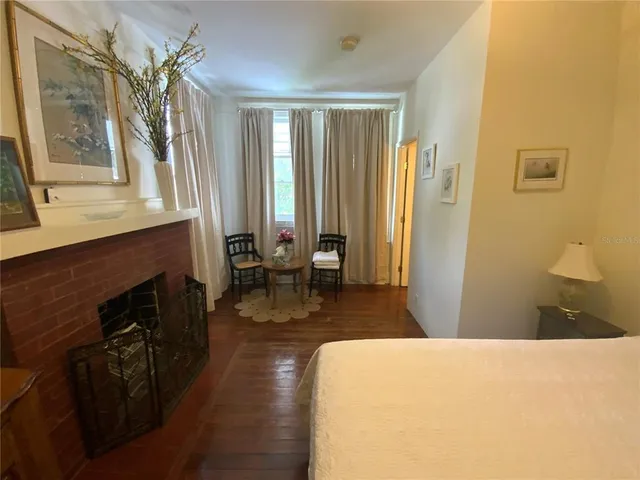 a living room with furniture a large window and wooden floor