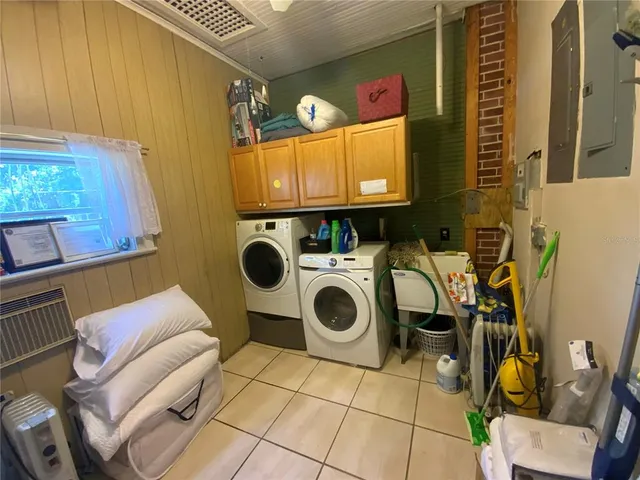a utility room with dryer washer and a view of living room