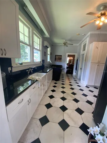 a large white kitchen with a black white checkered floor