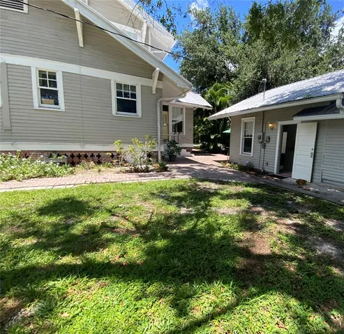 a view of a house with backyard and sitting area