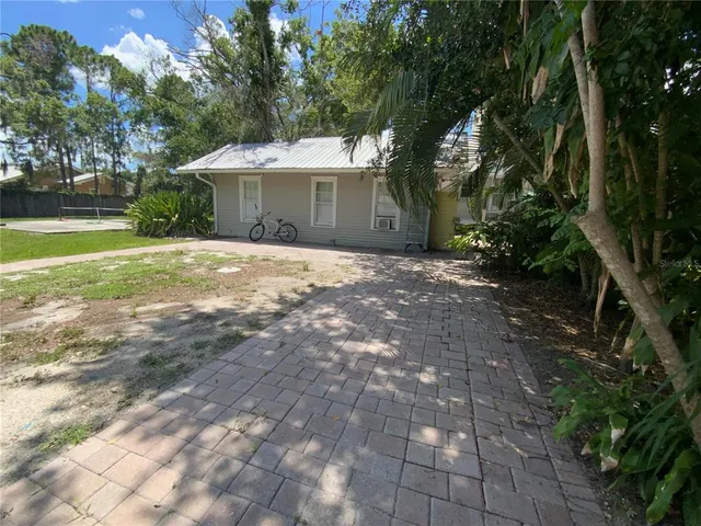a front view of a house with garden and trees